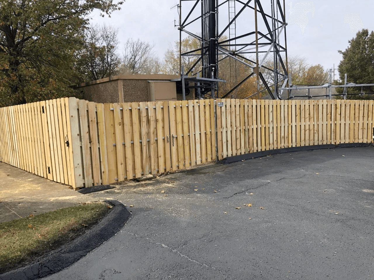 Wood commercial privacy fence enclosing utility equipment