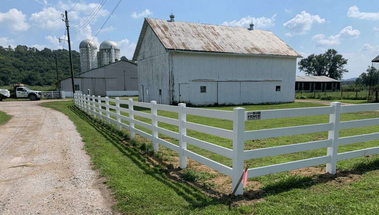 White vinyl ranch fence installed around farmhouse yard