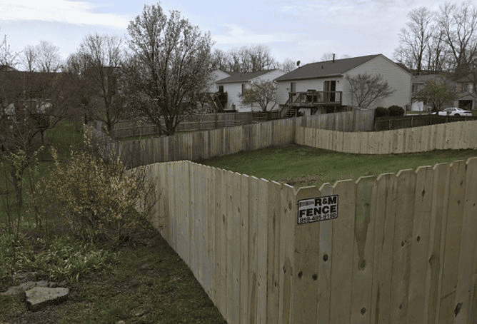 Wood privacy fence wrapping a sloped backyard corner
