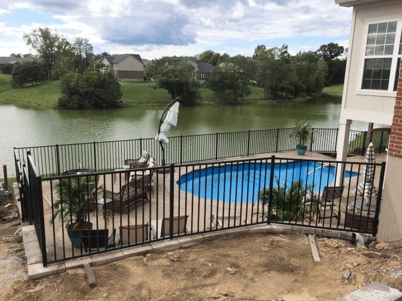 Black aluminum pool fence surrounding a backyard above-ground pool overlooking a lake in Kentucky