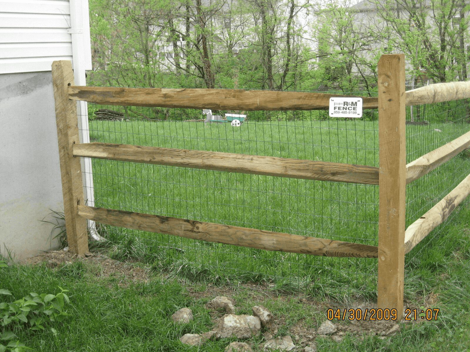 Close-up of split rail fence posts and rails with welded wire mesh for pet containment