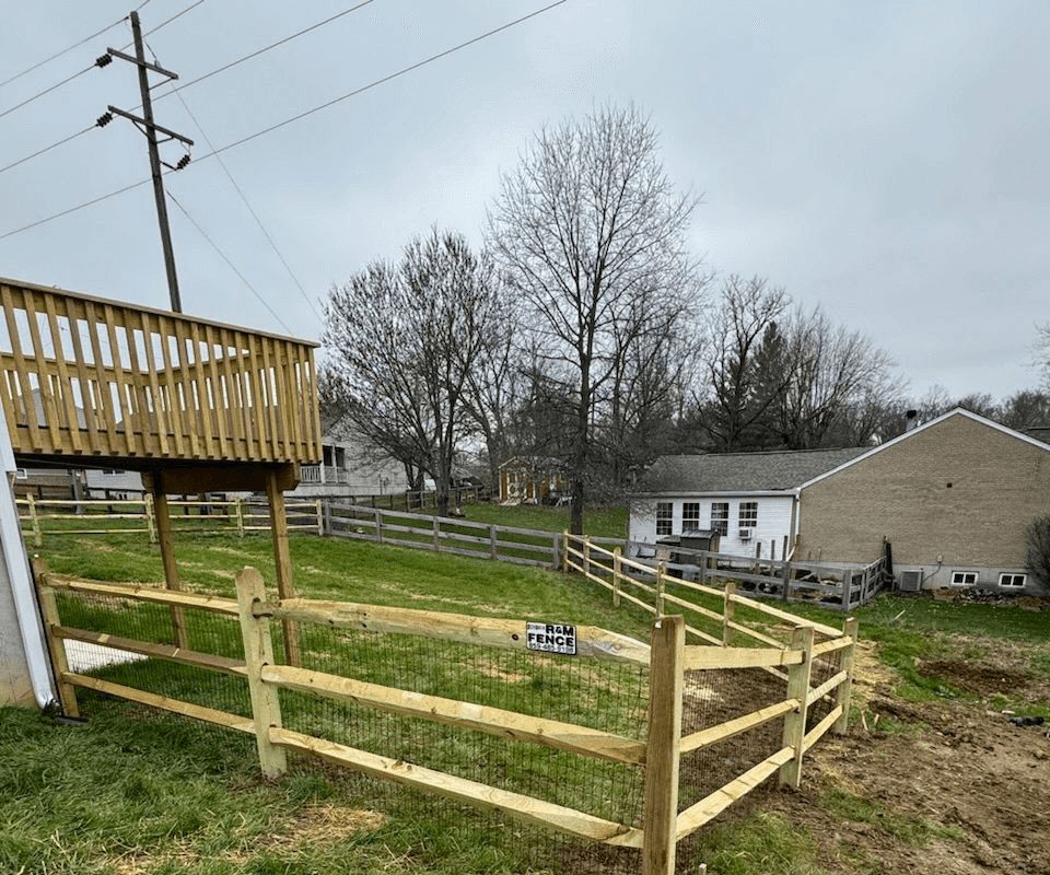 Split rail fence with wire mesh installed on a sloped backyard in Northern Kentucky