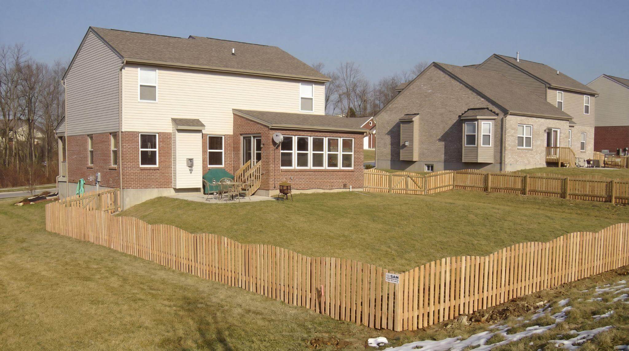 Wood picket fence enclosing a backyard, ideal for calm small-to-medium dogs