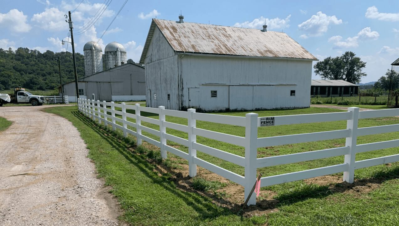 White vinyl ranch fence installed around farmhouse yard